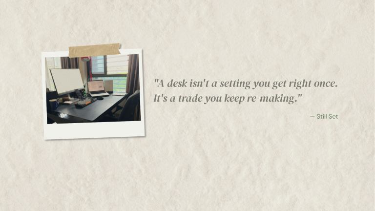 A softly blurred photo of a real work desk beside a window, with a lamp and coffee mug